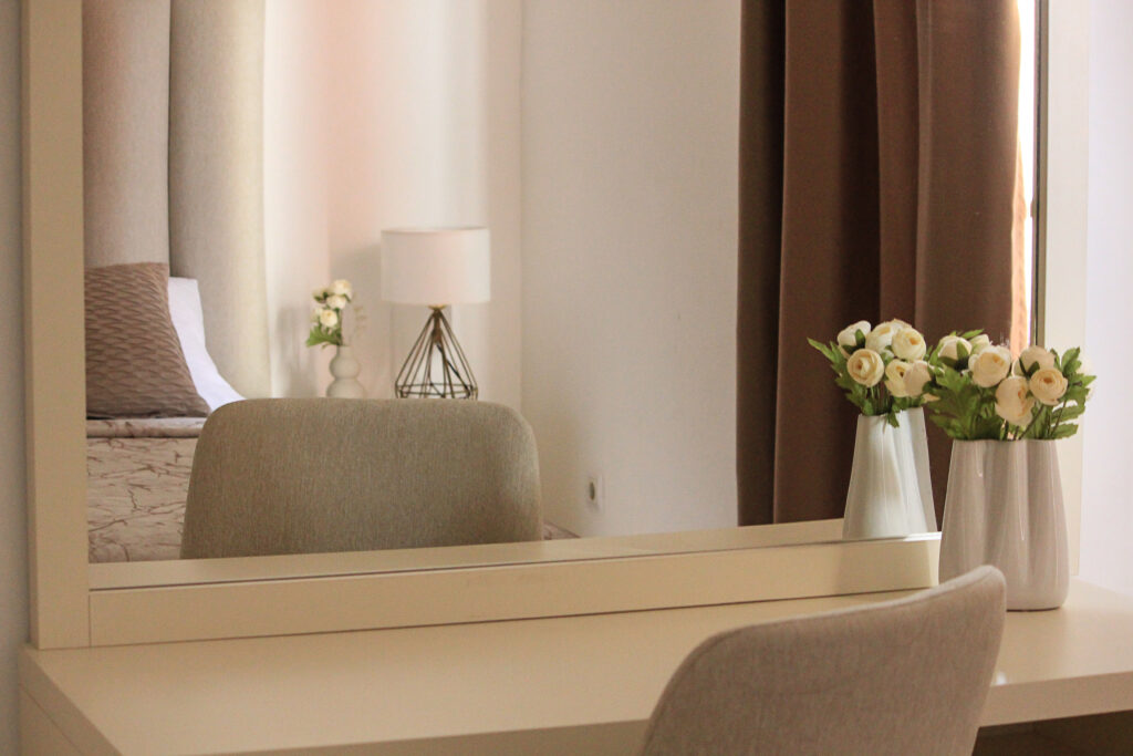 a desk with mirror in hotel room
