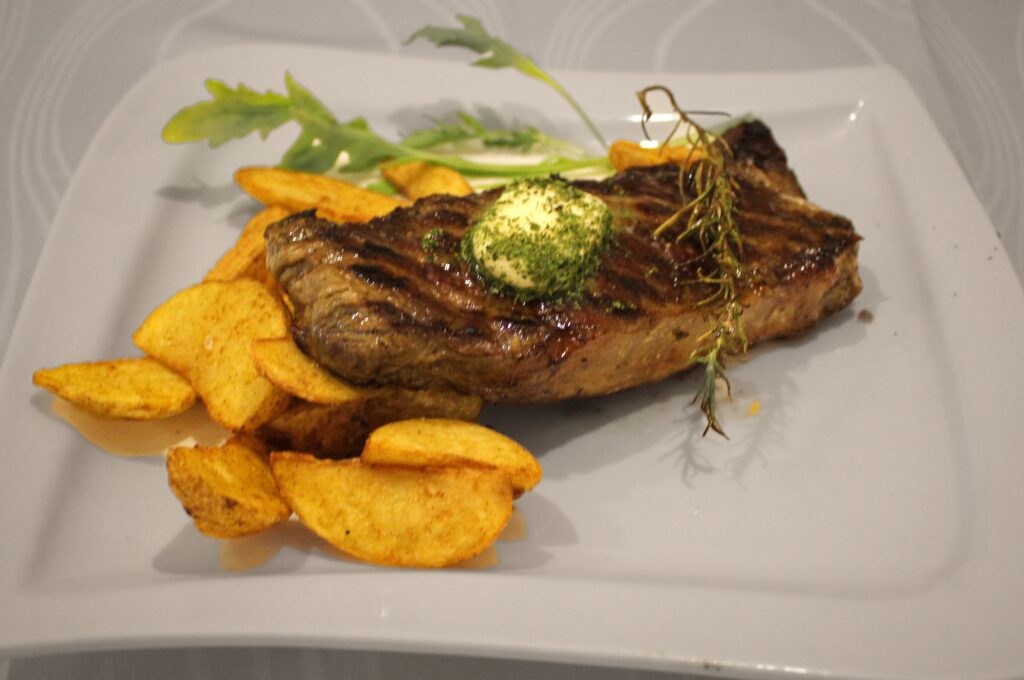 meat served with potato on a plate