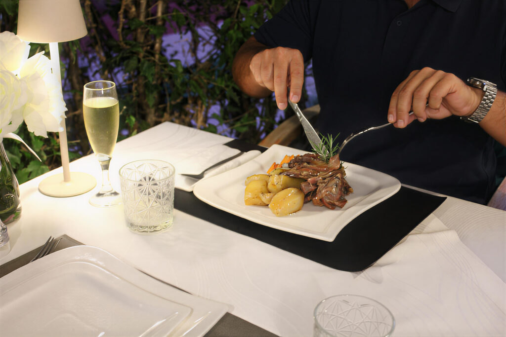a person cutting food on a plate