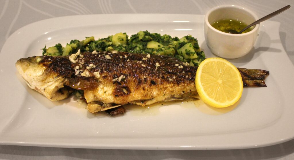 fish served for dinner on a plate with lemon