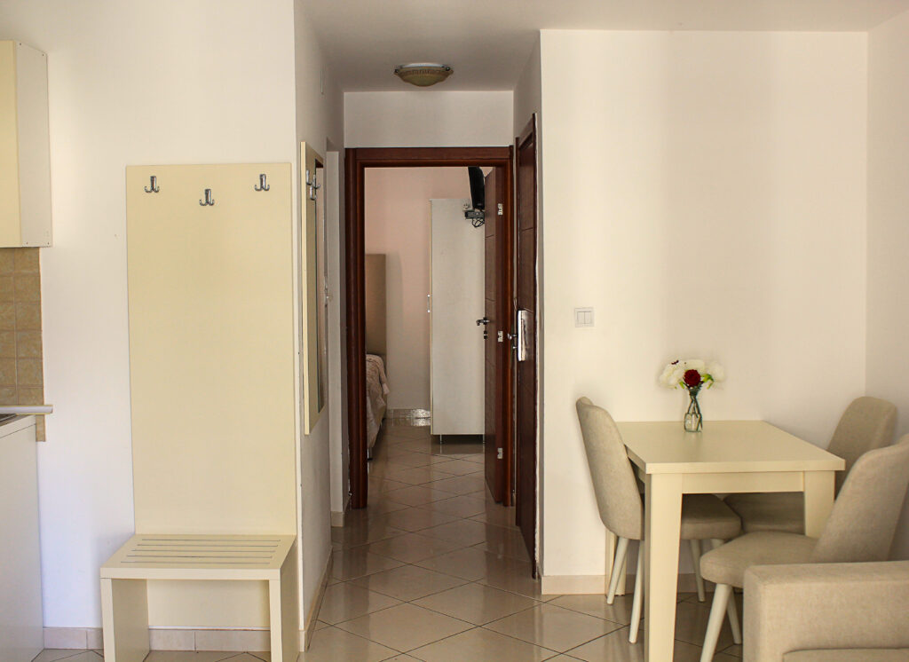 dining table with chairs and hallway in a hotel room
