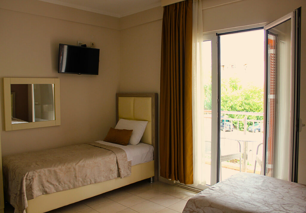 a single bed in a corner of the hotel room